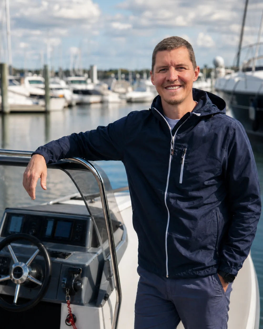 Marius Gehler, Gründer von Boatpass, am Steuerstand eines Motorboots im Hafen